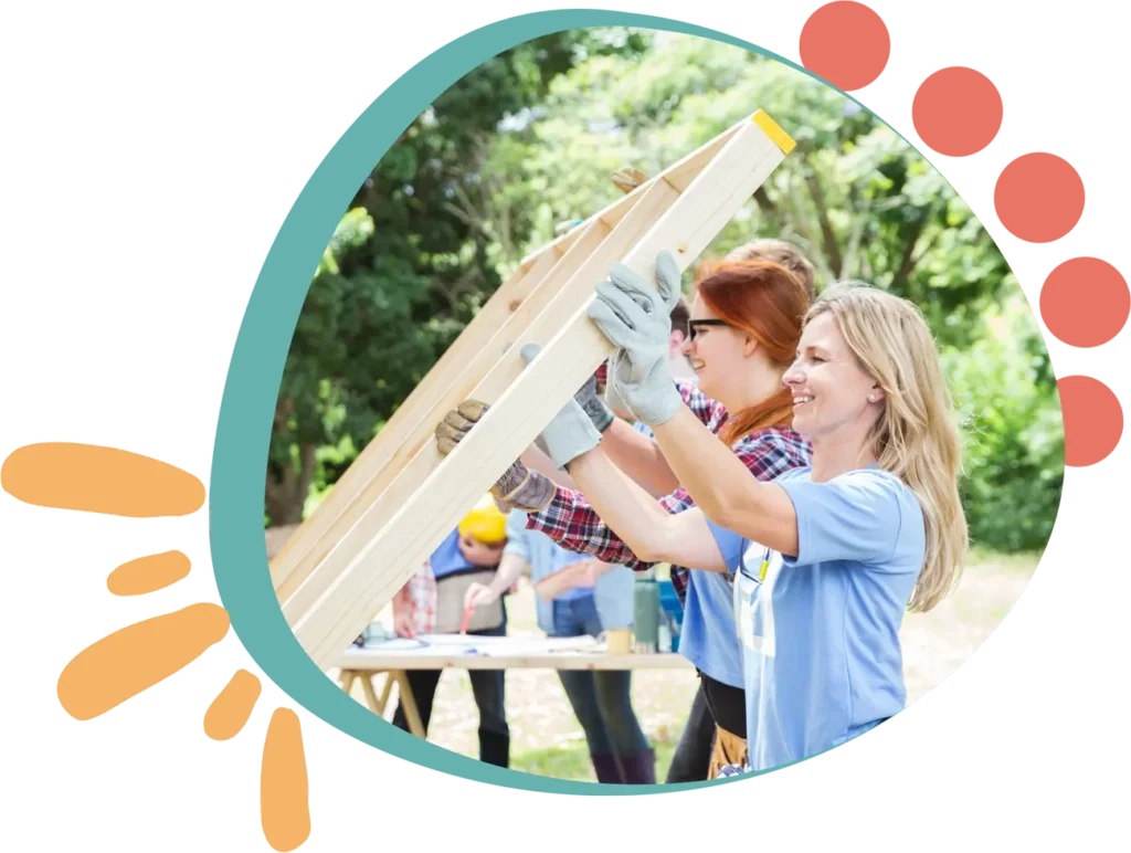 Two women volunteers building a house